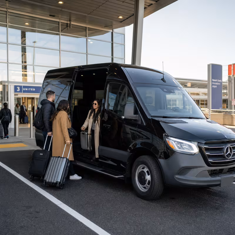 Group boarding a white charter bus for Airport Transportation transportation in Fort Lee
