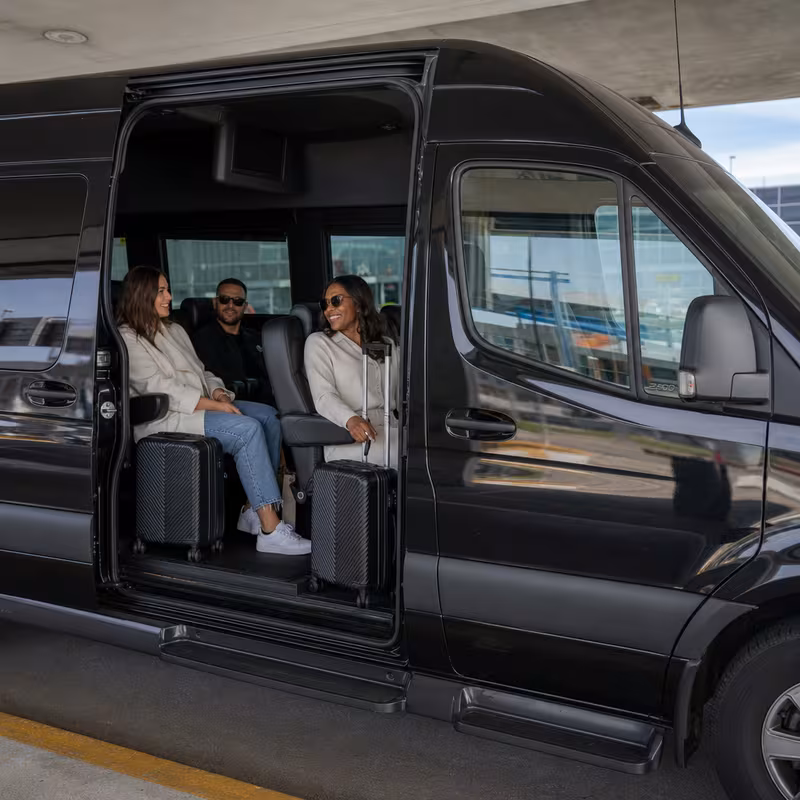 Passengers loading luggage while boarding an Fort Lee group shuttle